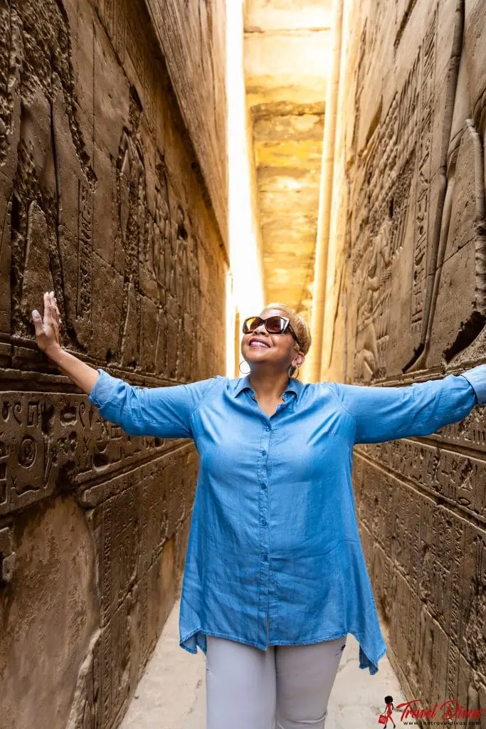 Travel Diva in Egyptian ruins with hieroglyphics on the walls