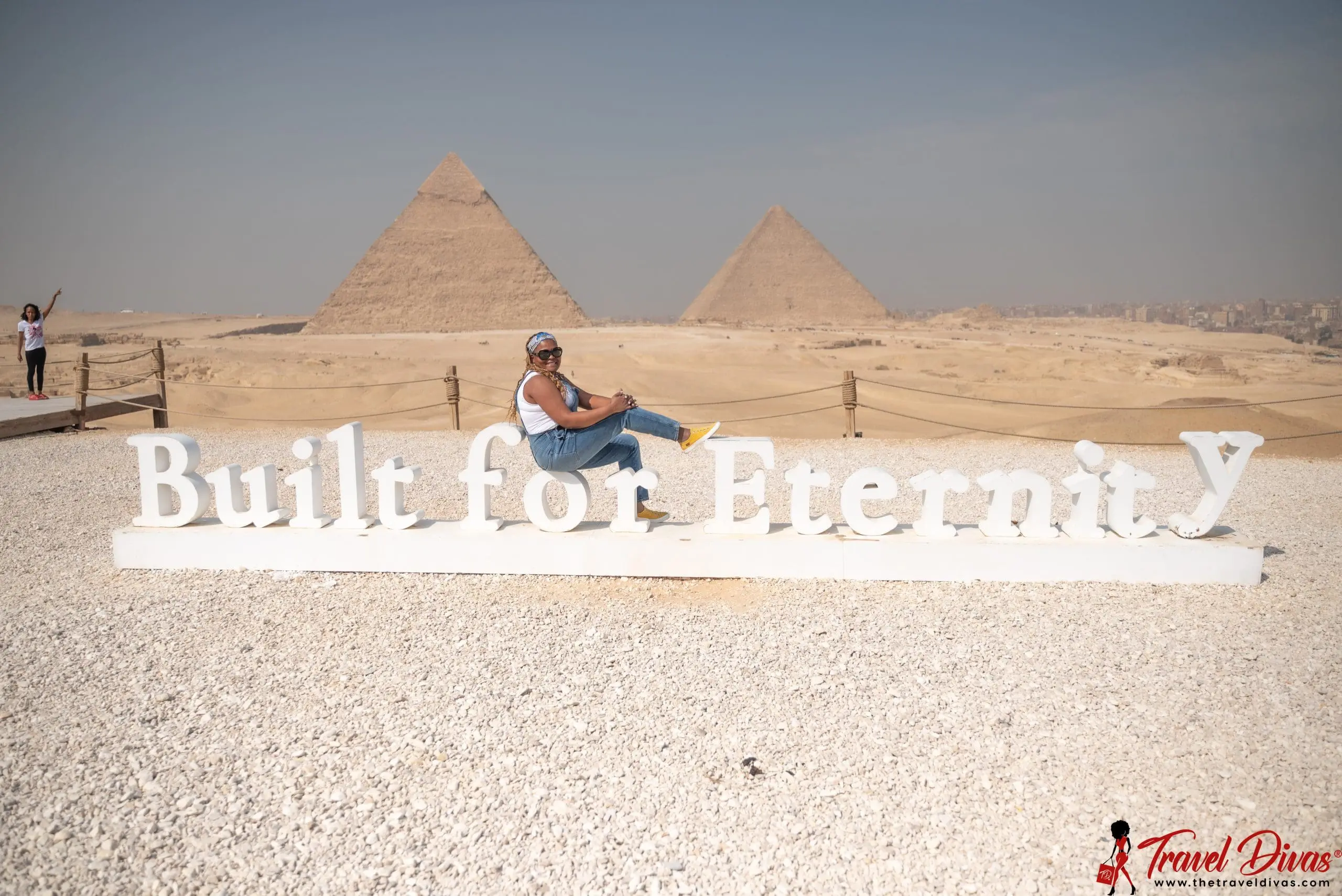 Travel Diva on Built for Eternity sign in front of Giza Plateau in Egypt