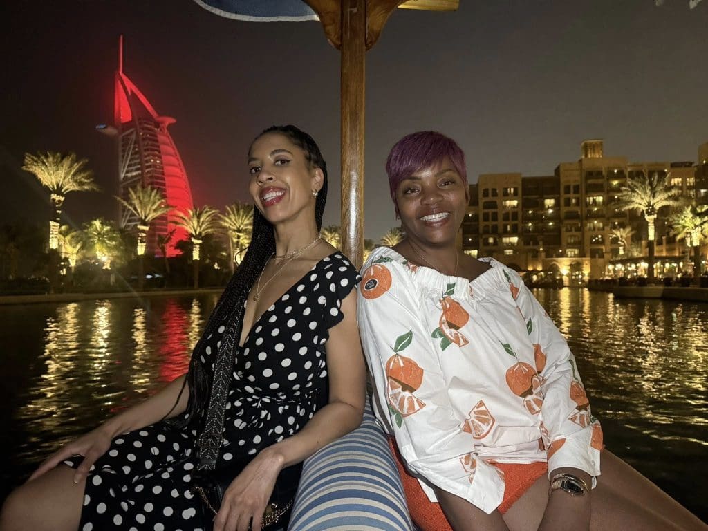 Travel Divas guests posing in front of the Burj Al Arab at sunset