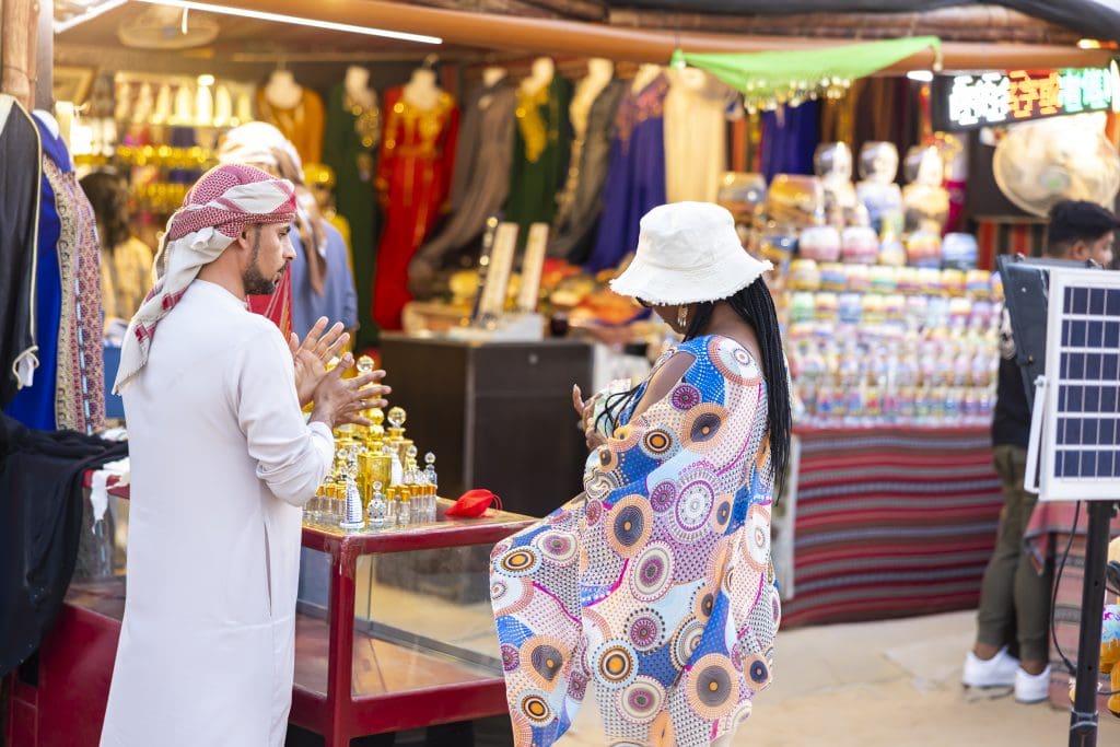 Black woman and Arabic vendor in outdoor shopping stall in Dubai