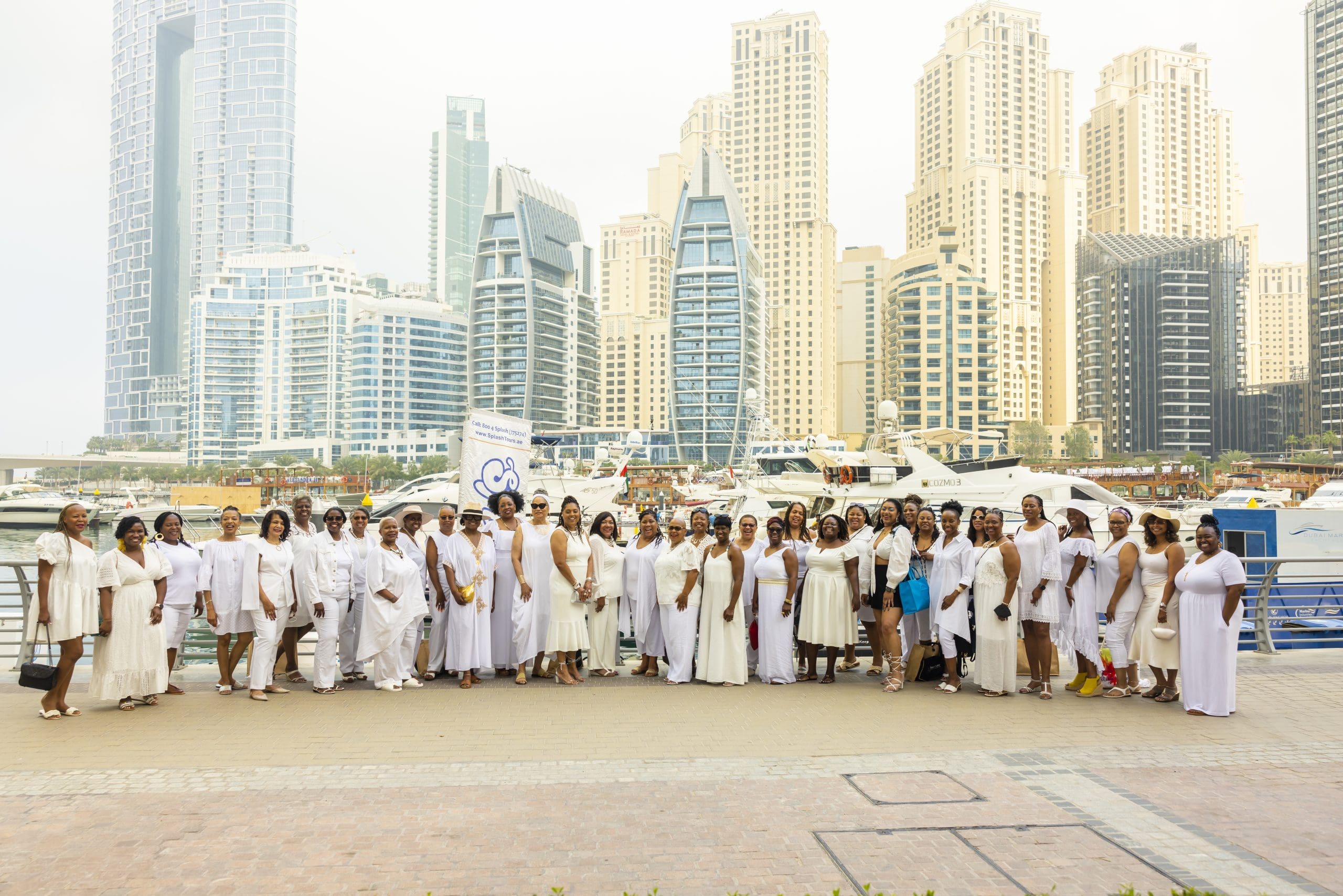 Group of black woman in Dubai all in white in front of Dubai city line