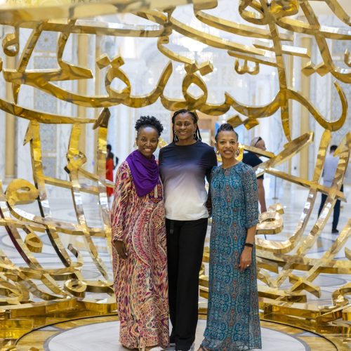 Black women in Dubai standing in front of gold sculpture