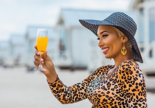 Beautiful mixed race Woman wearing stylish elegant leopard outfit on a beach